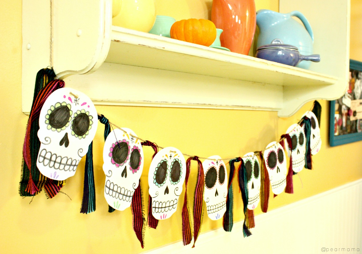 Make this simple Dia de los Muertos-inspired garland made from dollar store foam skulls, jute twine, markers and Mexican fabric.